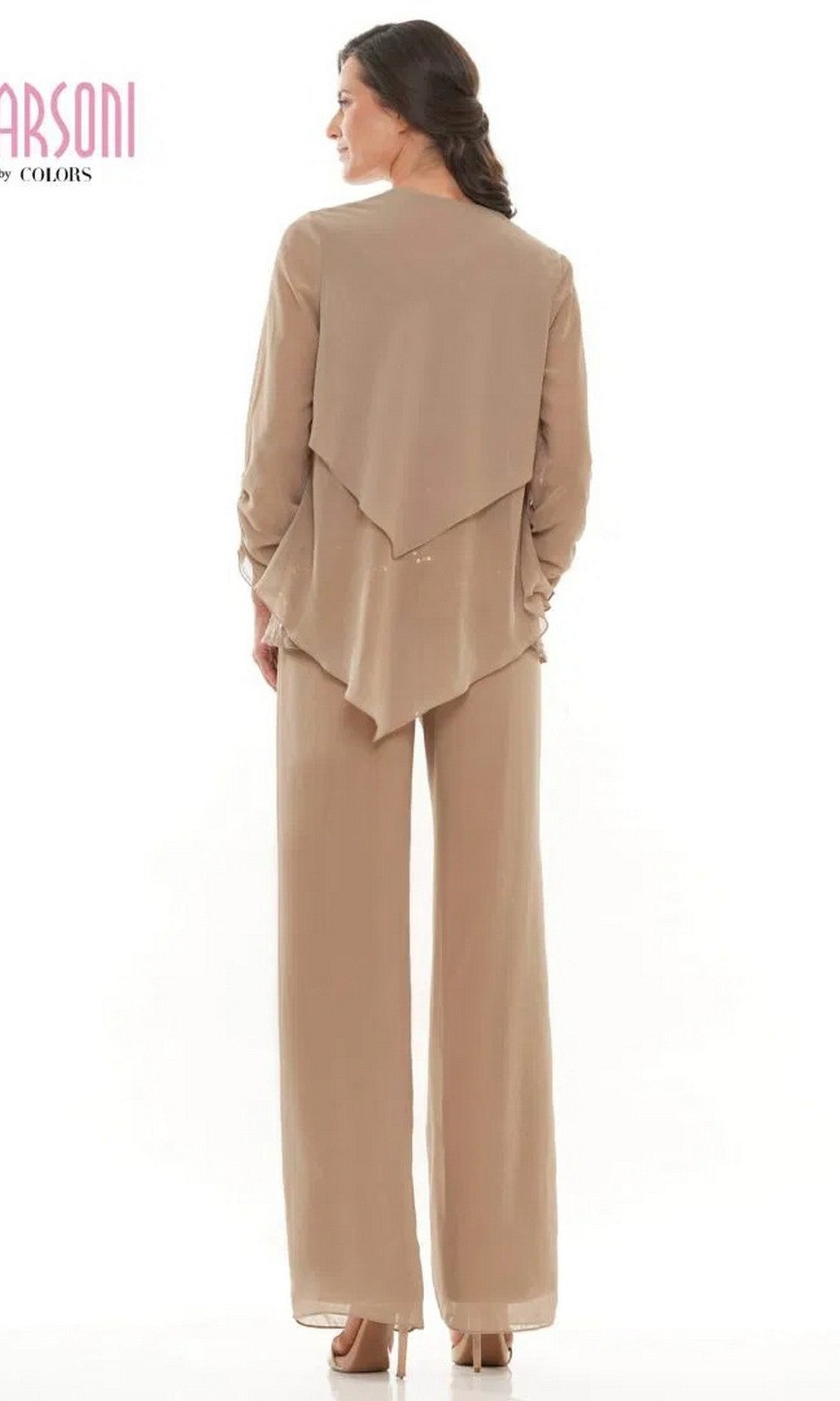 A woman with medium-length brown hair styled in a low braid faces away, wearing the Marsoni M303 long formal pantsuit—tan, loose-fitting, with long sleeves and layered back panels.